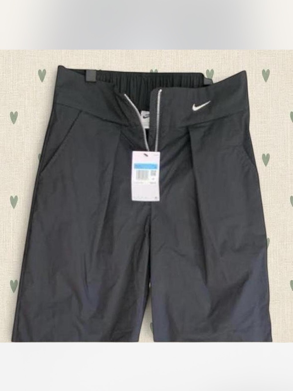 Womens nike black high-waisted wide-leg trousers with pleats and zipper detail.